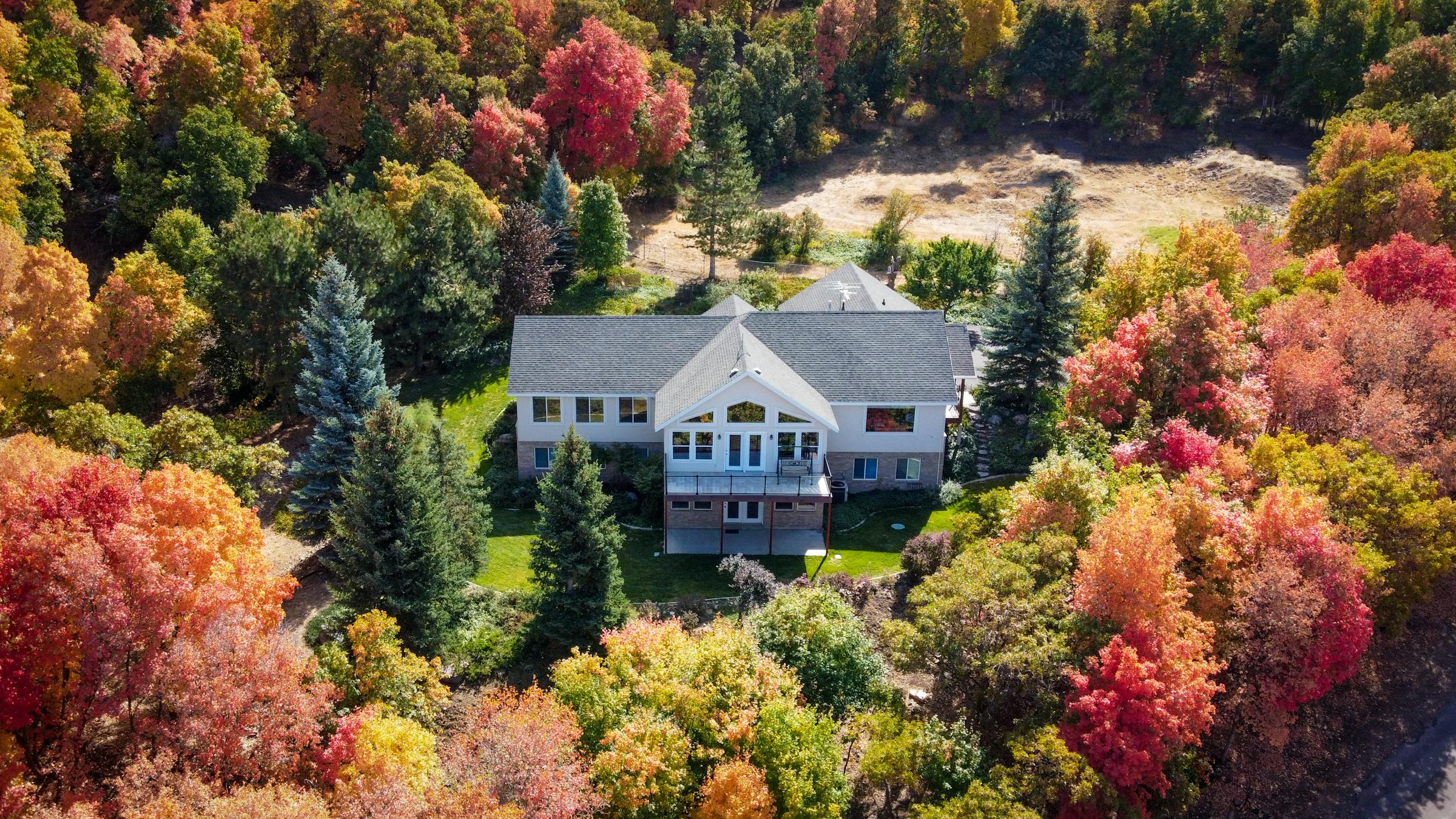 Home framed by autumn color at the base of the mountains